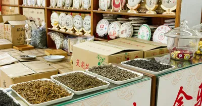 Plantas secas y tés expuestos en bandejas en una tienda de productos herbales de Pekín, China